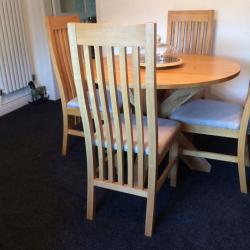 Next dining table and 4 chairs in light oak and chairs are covered in light grey fabric